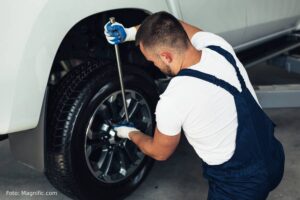 Mecânico arrumando pneu do carro