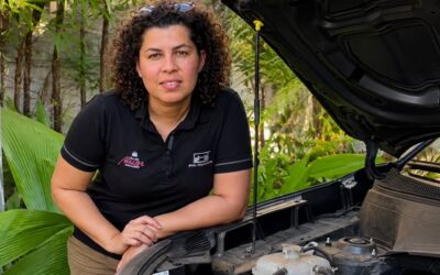 Bárbara Brier apoiada próximo ao motor de um carro