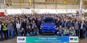 Funcionários ao lado do 1° Geely EX5 EM-i produzido no Brasil