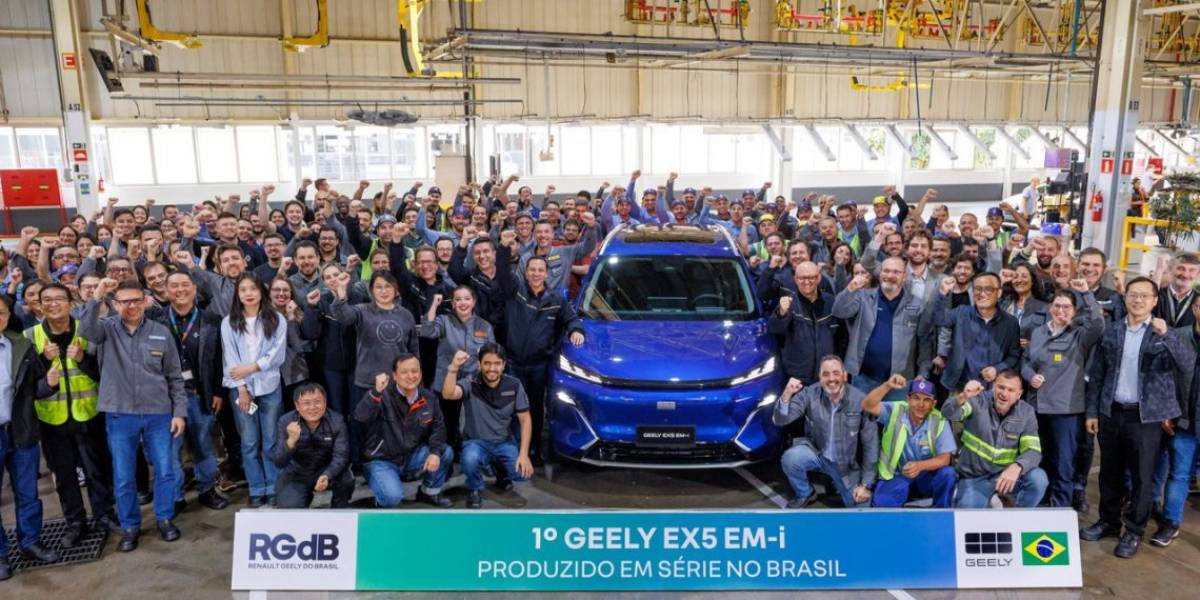 Funcionários ao lado do 1° Geely EX5 EM-i produzido no Brasil